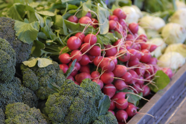 KI generiert: Frisches Gemüse auf einem Marktstand, Radieschen und Brokkoli im Fokus.