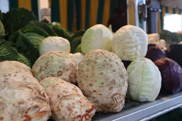 KI generiert: Verschiedene Kohlköpfe und Sellerie auf einem Marktstand.
