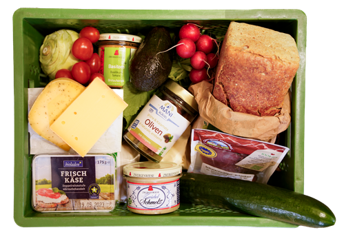KI generiert: Grüne Kiste gefüllt mit verschiedenen Lebensmitteln: Brot, Gemüse, Käse, Oliven. Text: "Frisch Käse" und "Oliven".